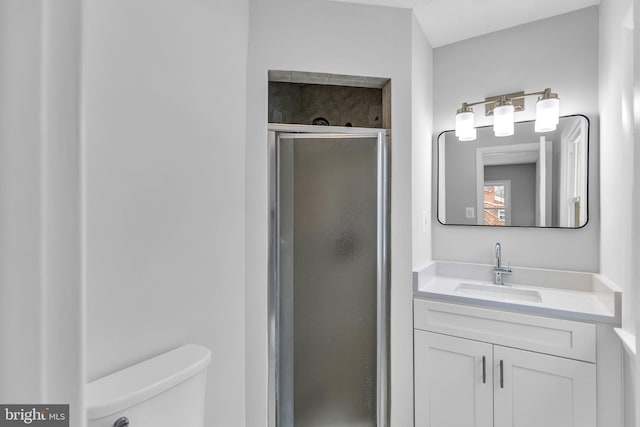 bathroom with vanity, toilet, and a shower with door