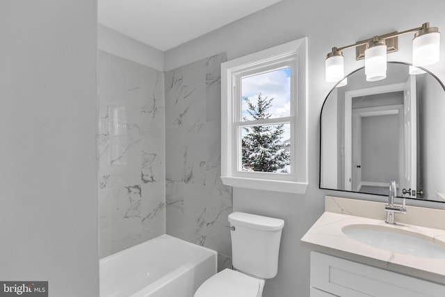 full bathroom featuring vanity, tiled shower / bath combo, and toilet