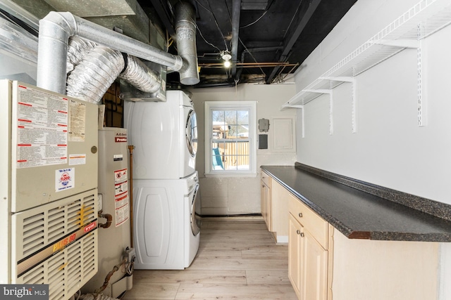 utility room featuring gas water heater, stacked washing maching and dryer, and heating unit