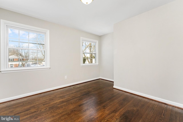 unfurnished room with dark hardwood / wood-style flooring