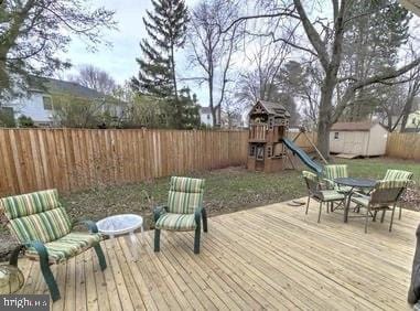 deck featuring a storage shed and a playground