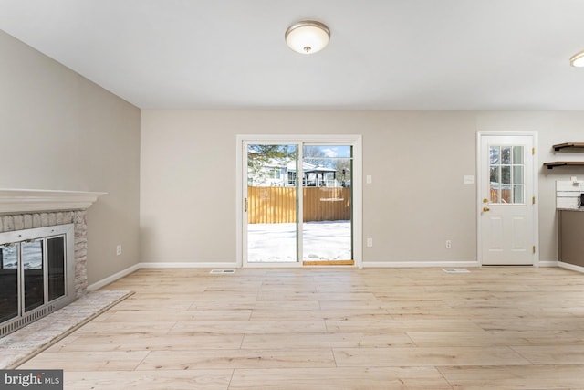 unfurnished living room with a fireplace and light wood-type flooring