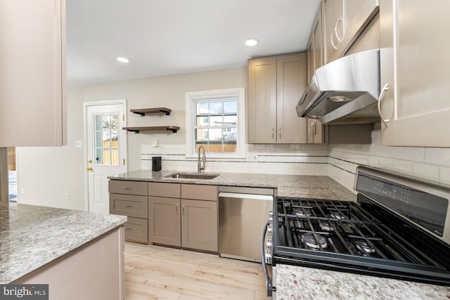 kitchen with dishwasher, sink, black gas range oven, light hardwood / wood-style floors, and exhaust hood