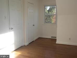 unfurnished bedroom featuring baseboards and wood finished floors