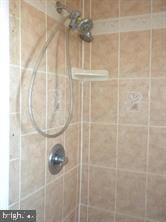 interior details featuring tiled shower