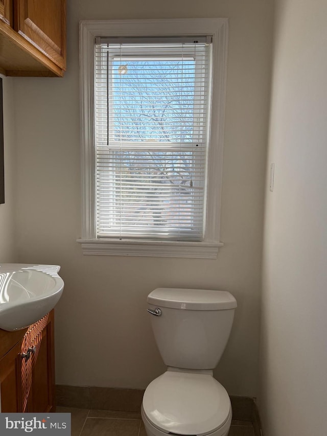 bathroom featuring tile patterned flooring, a healthy amount of sunlight, vanity, and toilet