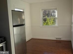 spare room featuring dark wood-type flooring and baseboards