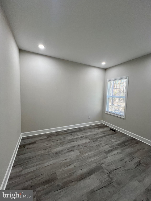 spare room with dark hardwood / wood-style flooring