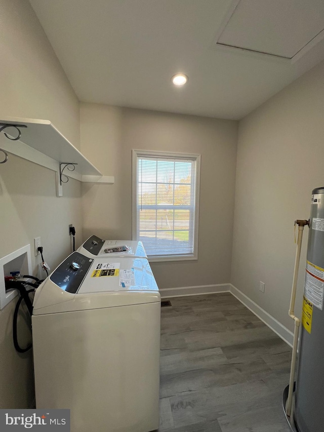 clothes washing area featuring gas water heater, hardwood / wood-style floors, and separate washer and dryer