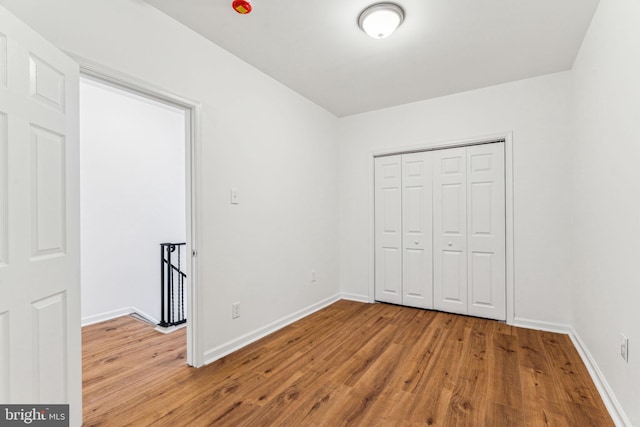 unfurnished bedroom featuring light hardwood / wood-style flooring and a closet