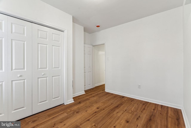 unfurnished bedroom featuring hardwood / wood-style flooring and a closet