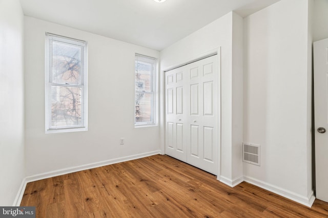 unfurnished bedroom featuring a closet and hardwood / wood-style floors