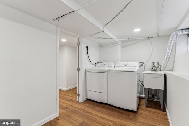 laundry room featuring wood-type flooring and independent washer and dryer