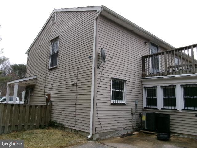 view of home's exterior with cooling unit and a balcony