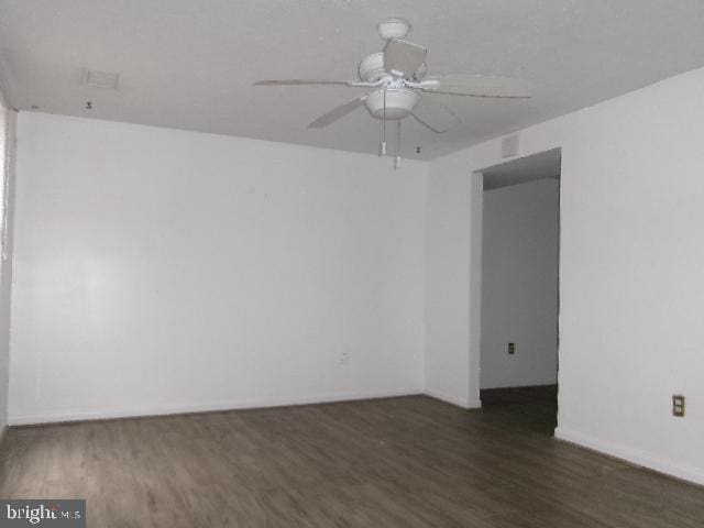 empty room with ceiling fan and dark hardwood / wood-style floors