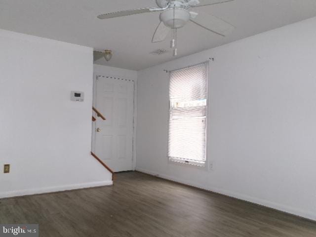 spare room with ceiling fan and dark wood-type flooring