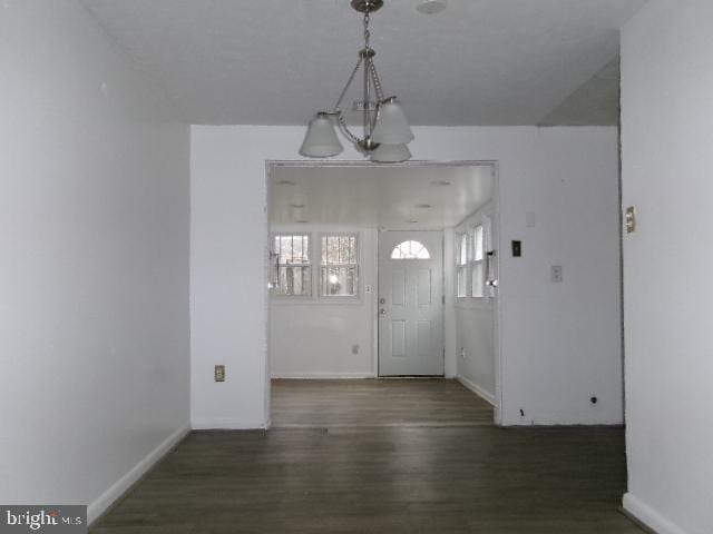 foyer with dark hardwood / wood-style floors and an inviting chandelier