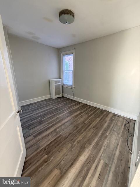 unfurnished room with dark hardwood / wood-style floors