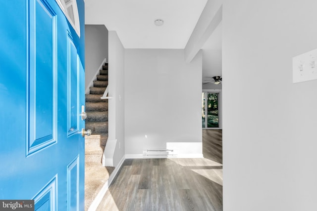 foyer entrance featuring ceiling fan, wood-type flooring, and a baseboard heating unit