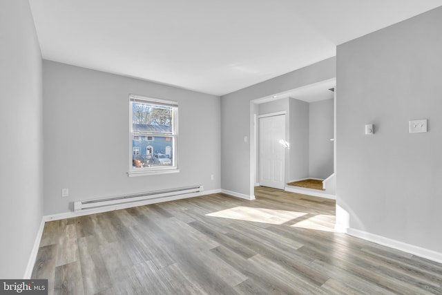 unfurnished room featuring light hardwood / wood-style flooring and a baseboard radiator