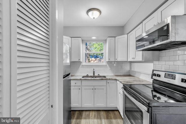 kitchen with stainless steel appliances, white cabinetry, and sink