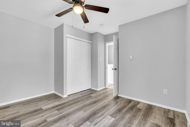 unfurnished bedroom featuring ceiling fan, light hardwood / wood-style flooring, and a closet