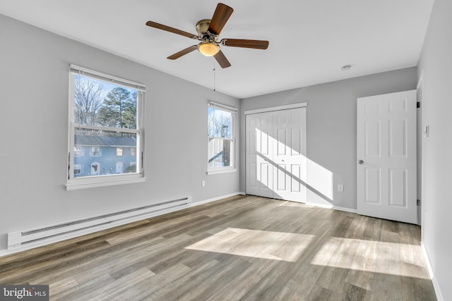 spare room with ceiling fan, light wood-type flooring, and a baseboard radiator