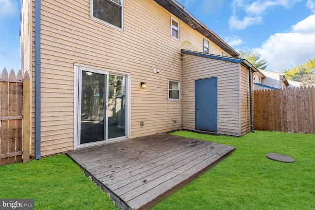 back of house featuring a lawn and a deck