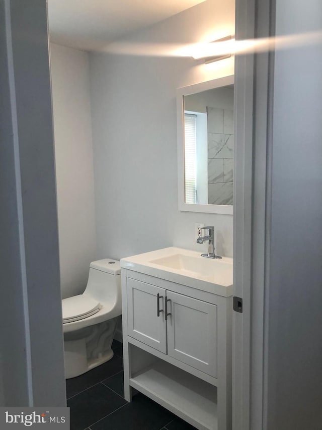 bathroom featuring tile patterned floors, vanity, and toilet