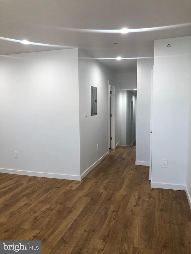 corridor with dark hardwood / wood-style floors and electric panel