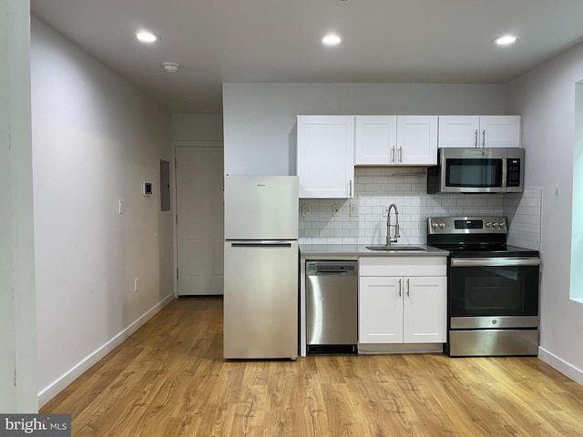 kitchen featuring sink, white cabinets, light hardwood / wood-style floors, and appliances with stainless steel finishes