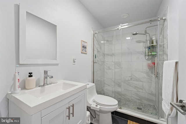 full bathroom featuring toilet, vanity, and a shower stall