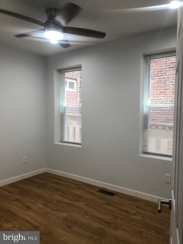 unfurnished room featuring ceiling fan, dark hardwood / wood-style flooring, and a wealth of natural light