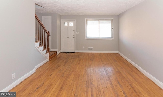 entryway featuring a textured ceiling and light hardwood / wood-style flooring