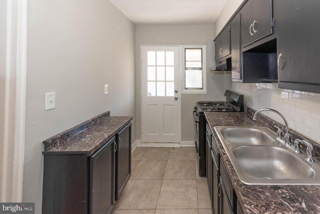 kitchen featuring decorative backsplash, black range with gas stovetop, sink, light tile patterned floors, and dark stone countertops