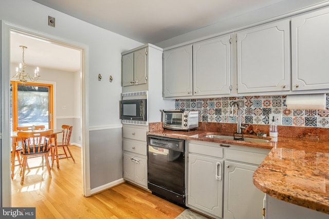 kitchen with white cabinets, sink, an inviting chandelier, and black appliances