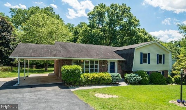 tri-level home with a carport and a front lawn