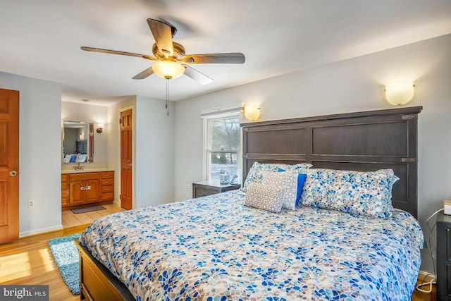 bedroom featuring light hardwood / wood-style flooring, ensuite bath, and ceiling fan