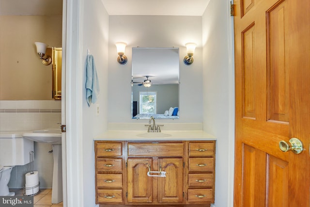 bathroom with ceiling fan, sink, tile walls, and tile patterned flooring