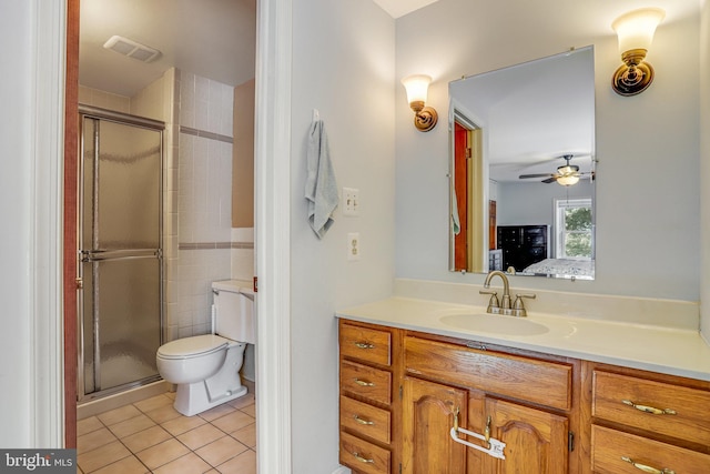 bathroom featuring vanity, a shower with door, tile patterned floors, ceiling fan, and toilet