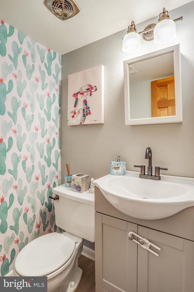 bathroom featuring vanity, wood-type flooring, and toilet