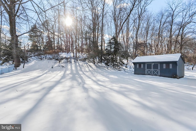 yard covered in snow featuring an outbuilding