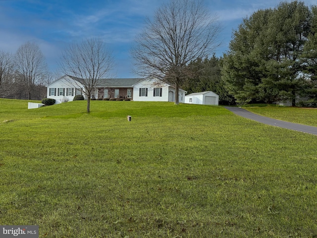 view of front facade featuring an outbuilding, a garage, and a front lawn