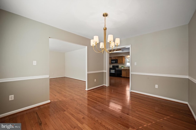 unfurnished dining area featuring hardwood / wood-style floors and a notable chandelier