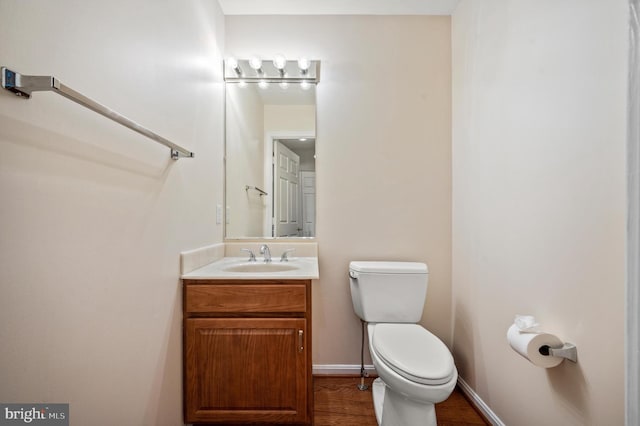 bathroom featuring vanity, wood-type flooring, and toilet