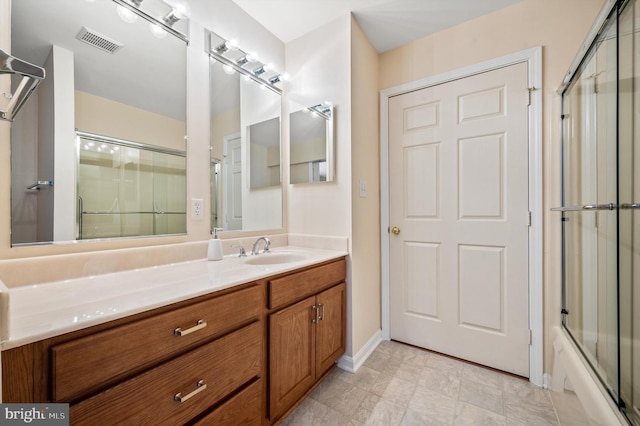 bathroom featuring vanity and shower / bath combination with glass door