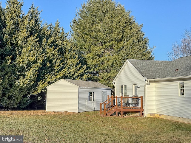 rear view of property with a wooden deck, a storage unit, and a lawn