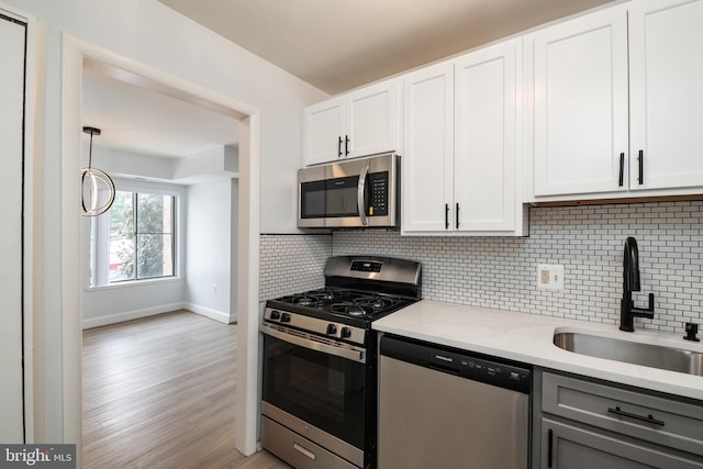 kitchen featuring light stone counters, sink, white cabinetry, and appliances with stainless steel finishes