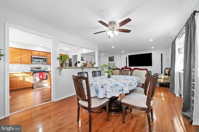 dining space with ceiling fan and light hardwood / wood-style flooring