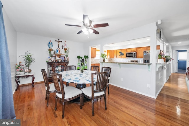 dining room with ceiling fan and light wood-type flooring